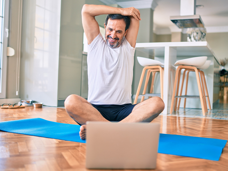 Man completing online physical therapy in his home