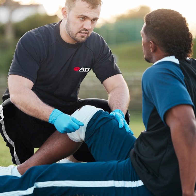 Athletic trainer administering physical therapy.