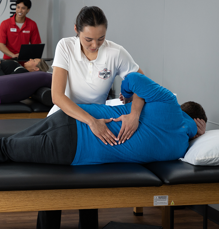 Physical therapist administering back treatment on a patient